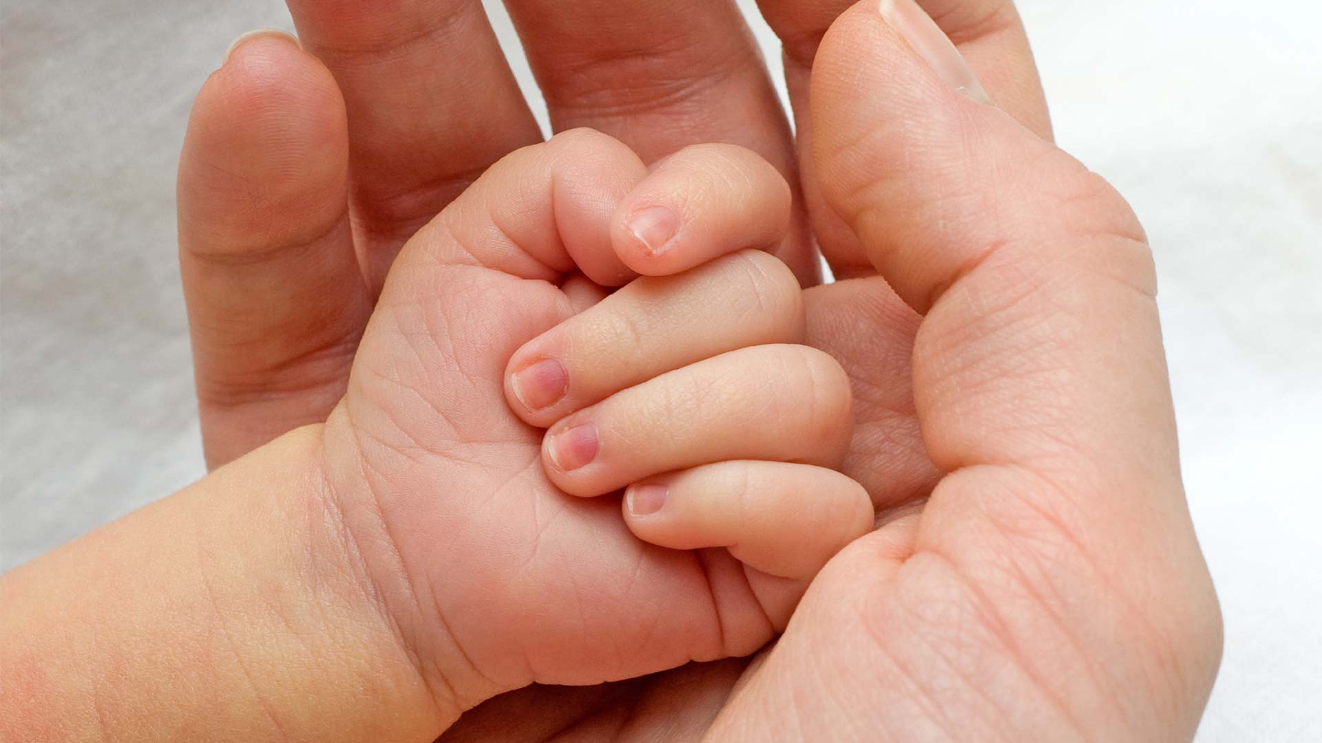 Baby hand in adult hand